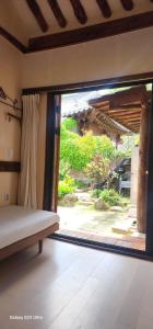 a bedroom with a large sliding glass door with a window at Eosahwa Hanok Stay Featured in Petit Futé 2026 in Jeonju