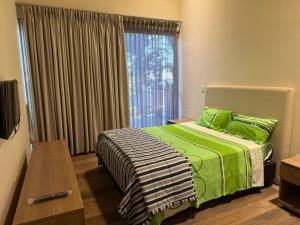 a bedroom with a bed with green sheets and a window at Paraíso del Anfiteatro in San Bernardino +9 photos