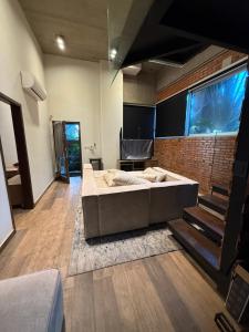a living room with a large bed and a brick wall at Paraíso del Anfiteatro in San Bernardino
