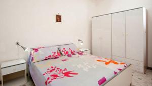 サンタ・マリア・アル・バーニョにあるLe Piramidi Appartamentiの白いベッドルーム(赤い花のベッド付)