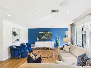 a living room with a couch and blue walls at Azure - Sparkling Pool - Pool Table - In Old Town in Scottsdale +55 photos