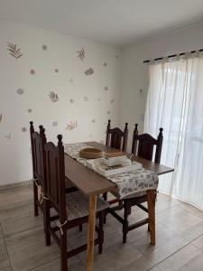a dining room with a wooden table and chairs at Las Magnolias CABAÑAS in Salta