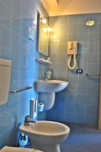 a bathroom with a sink and a toilet and a mirror at Residence Miljunka in SantʼAgata di Militello