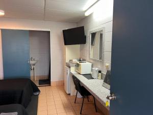 a room with a kitchen with a sink and a microwave at Fossil Outpost Eromanga in Eromanga