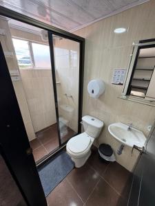 a bathroom with a toilet and a sink at Tauko Tú Casa in Paipa