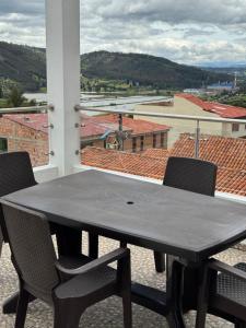 a black table and chairs on a balcony with a view at Tauko Tú Casa in Paipa