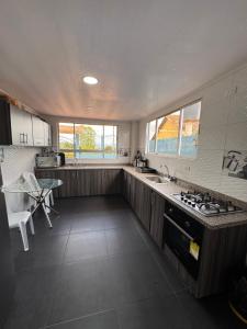 a kitchen with a sink and a stove top oven at Tauko Tú Casa in Paipa +27 photos