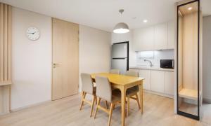 a kitchen and dining room with a wooden table and chairs at Belle Fore Resort in Jeungpyeong