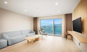 a living room with a couch and a tv at Belle Fore Resort in Jeungpyeong