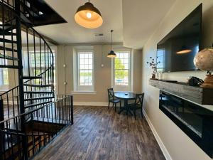 a living room with a staircase and a table at Harbor Hideaway Suite - River Rock Inn in Bellevue
