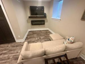 a living room with a couch and a flat screen tv at Harbor Hideaway Suite - River Rock Inn in Bellevue