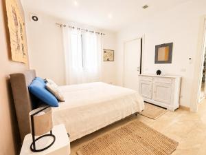 a white bedroom with a bed and a window at Villa Dolce Vita in Triscina