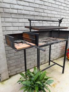 a grill on a table in front of a brick wall at Las Magnolias CABAÑAS in Salta