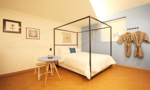 a bedroom with a bed and a table in a room at Iksan 4 Seasons Hotel in Iksan