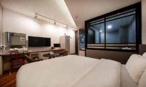 a bedroom with a bed and a desk and a large window at Iksan 4 Seasons Hotel in Iksan
