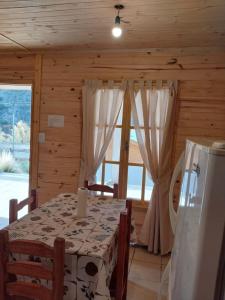 a dining room with a table and a large window at Vista del Plata - Alojamiento in Potrerillos