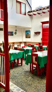 a dining room with green tables and red chairs at Hotel La Casona in Jardin