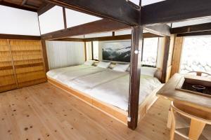 a bed in a room with a wooden floor at Nagi no Ne in Washika