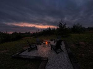 a fire pit with two chairs and a table with a fire at Spruce Arch - King Bed Fireplace Pets Welcome in Rogers