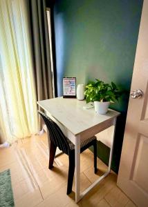 a white table with a plant on it in a room at 2BR Italian-inspired Condo Unit, Balcony Pool View in Manila
