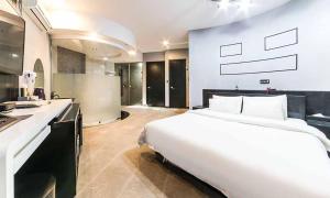 a bedroom with a large white bed and a bathroom at Paju Picasso in Paju
