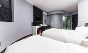 a bedroom with two beds and a desk in it at Paju Picasso in Paju