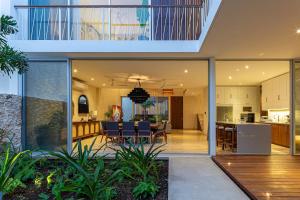 an open kitchen and dining room with sliding glass doors at Casa del Paseo Luxury Home in Centro Rooftop Bar & 2 Pools in Mérida