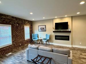 a living room with a couch and chairs and a tv at Mill View Suite - River Rock Inn in Bellevue