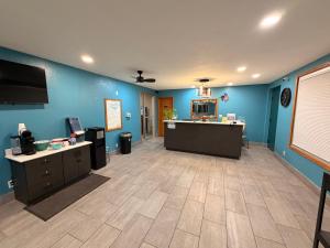 a large room with blue walls and a desk at Best Nights Hotel in Fond du Lac
