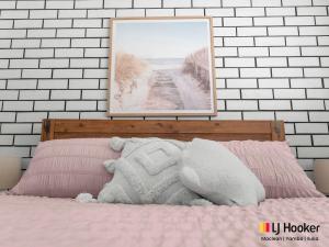 a bedroom with a bed with a picture on the wall at Barefoot by the Bay in Iluka