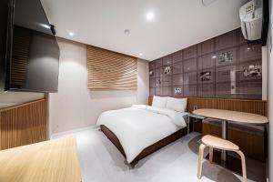 a small bedroom with a bed and a table at Hotel Salmon in Seoul