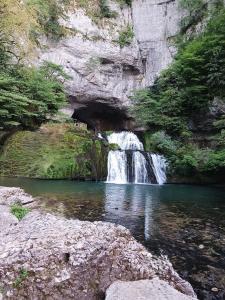 a river with a waterfall in a rocky canyon at La R'mise de Surcey in Alaise