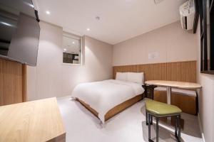 a small bedroom with a bed and a table at Hotel Salmon in Seoul