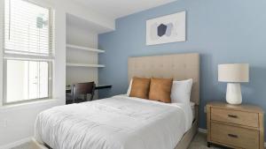 a bedroom with a bed with blue walls and a window at Landing Apartments - Reserve at City Place in Conroe +38 photos