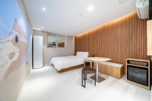 a hotel room with a bed and a table and a tv at Hotel Salmon in Seoul