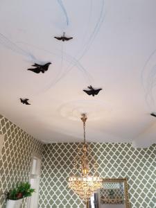 een kroonluchter met vogels aan het plafond van een kamer bij Cozy Sintra Townhouse in Sintra