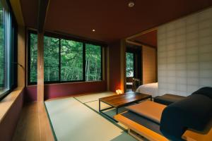a bedroom with a bed and a table and a couch at Boscage Kariya in Yugawara