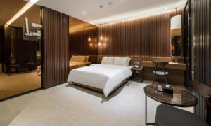 a bedroom with a bed and a desk and a table at Hotel Mayotte in Uiwang