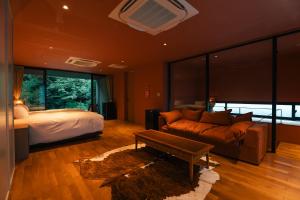 a bedroom with a bed and a couch and a bed and a bed sqor at Boscage Kariya in Yugawara +31 photos