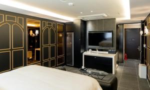 a bedroom with a bed and a sink and a tv at Hotel Mayotte in Uiwang