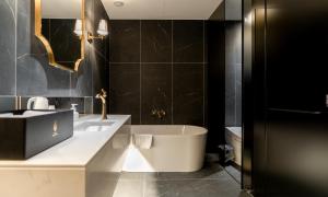 a black bathroom with a tub and a sink at Hotel Mayotte in Uiwang