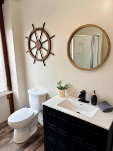 a bathroom with a toilet and a sink and a mirror at Paddle Wheel Suite-Potter’s Mill in Bellevue