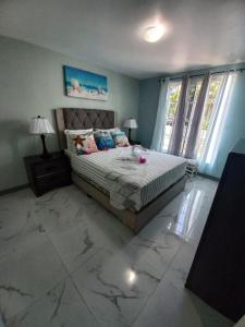 a bedroom with a bed and a large window at Sea Castles La Vue in Montego Bay +40 photos