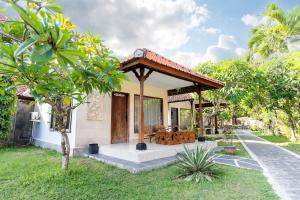 a house with a gazebo in the yard at Ganesh Lodge in Candidasa