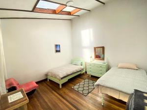 a room with two beds and a dresser and a window at Casa Colonial 924 in La Paz