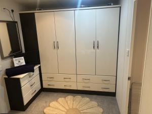 a large closet with white cabinets and a rug at Olive Tree Lodge in West Thirston