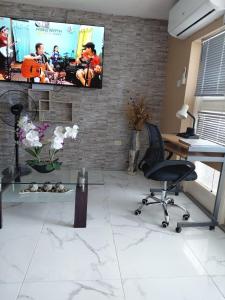 an office with a desk and a television on a brick wall at Sea Castles La Vue in Montego Bay