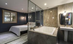 a bathroom with a bed and a bathtub and a bath tub at Hotel H2 in Ulsan