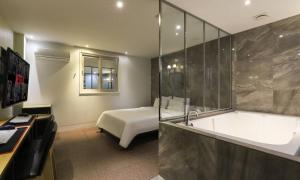 a bedroom with a bed and a bathtub and a tub at Hotel H2 in Ulsan