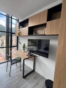 a room with a desk and a tv in a room at Diseño, vistas Monserrate WiFi 300Mb in Bogotá